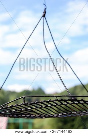 Old Greasy Bent Grill Grate Sky And Woods In The Background, Camping And Grilling In The Wild Campfi