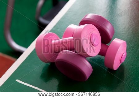 Two Pink Dumb Bells Laying On The Table Pong Table. Feminine Workout Symbol, New Female Gym Area Hea