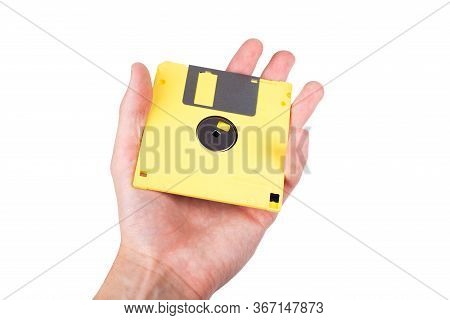 Single Bright Yellow Floppy Disk, Pastel Computer Diskette Being Held In Hand, Shown, Presented To T