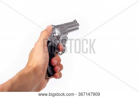 Hand Holding A Silver Gun Pulling The Trigger, Revolver In Hand Pointed Away. Wild West Handgun Silv