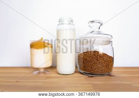 Ingredients For Dalgona Coffee. Instant Coffee And Milk In Glass Jars On Wooden Table. Iced Dalgona 