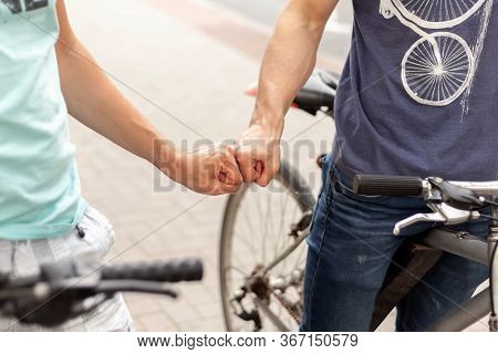 Two Friendly Young Bikers Fist Bumping Each Other On The Street Closeup. Fistbump On The Road, Bike 