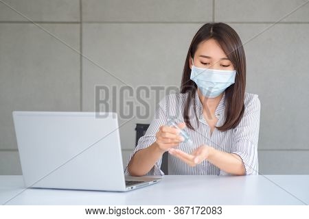 Business Woman Wearing Mask And Using Personal Sanitizer To Cleaning Her Hand In Office To Keep Hygi