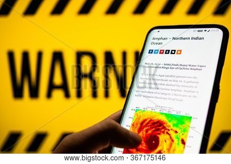 Mobile Phone Logged Into Photo Of Cyclone With Warning Background