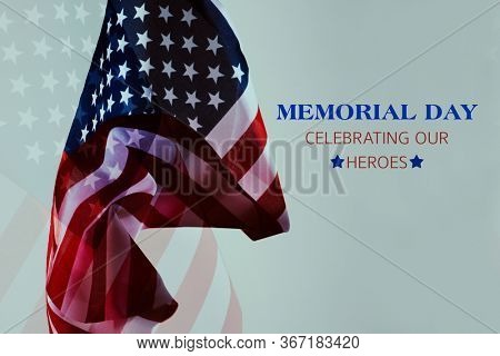 multiple exposure of some flags of the United States of America and the text memorial day celebrating our heroes against an off-white background