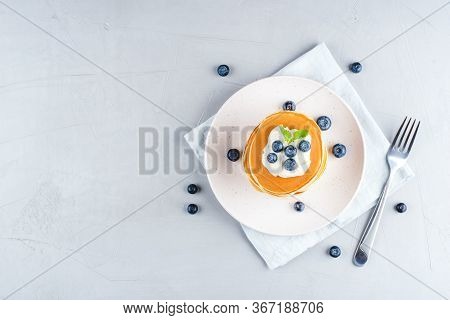 A Stack Of Pancakes With Fresh Blueberries And Cheesecream. Top View.