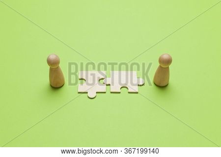 Wooden Figures With Pazzles On Green Background. Agreement Between Business Mans, Cooperation And De