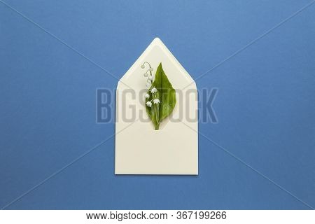 May Fresh Lily Of The Valley In A Mail Envelope On A Blue Background. Wedding Invitation Concept, Ro
