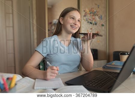 Happy Smiling, Teenager Girl Talking And Recording A Voice Message, Smartphone, Laptop Lessons At Ho