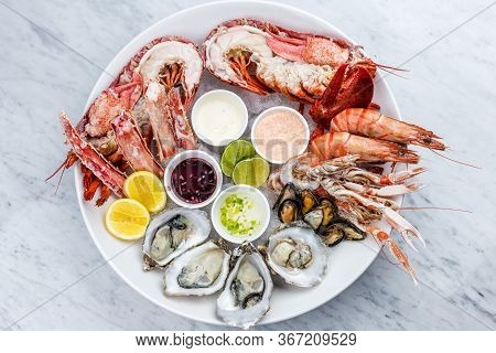 Mixed Fresh Seafood Platter Of Oysters, Lobster And King Prawns Placed On The Ice