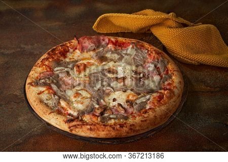 Homemade Pizza With Mushroom Sauce, Ham, Mushrooms, Tomato Paste Over Dark Surface. Selective Focus.