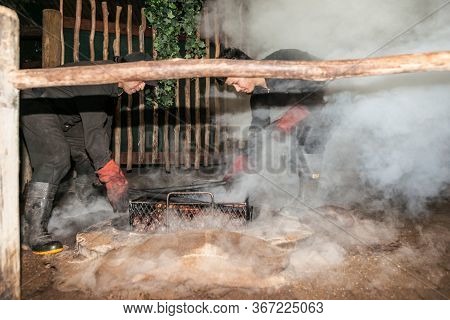 Rotorua New Zealand - April 23 2014; Smoke And Dust Fly As Food Is Being Prepared For A Traditional 