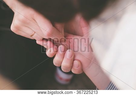 A Splinter In The Hand Of A Child. Girl Pulls A Splinter From The Hands Of A Child.