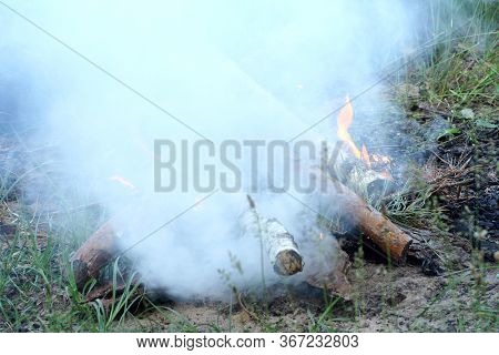 Fracing The Fire. White Smoke Over Flames And Wood Out Of Campfire