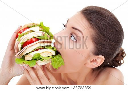 Jeune femme mordre dans un très gros pain maison rempli de tomate et le bacon sur une backg blanc