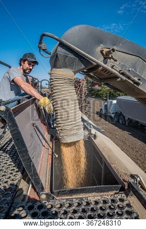 Swift Current, Sk/canada- May 15, 2020: Young Farmer Loading Wheat Seed From The Super B Into The Bo