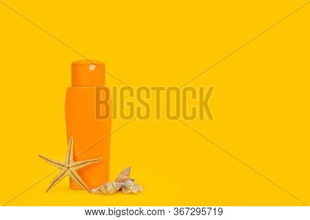 An Orange Suntan Cream Bottle On An Yellow Background With Copy Spcae