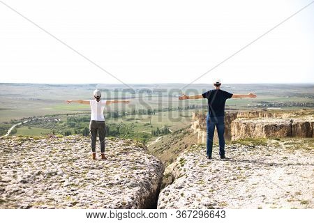 Woman And Man In Social Distancing Standing Outdoors On The Rock.