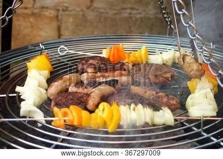 Some Barbecue Food Over A Barbecue. Kababs, Sausages And Burgers.