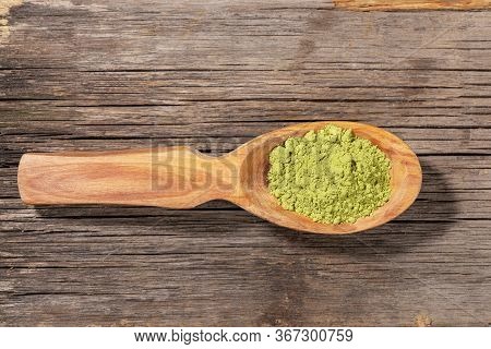 Wooden Spoon With Japanese Green Matcha Tea Powder On Old Wooden Board. Matcha Tea Is Organic Health