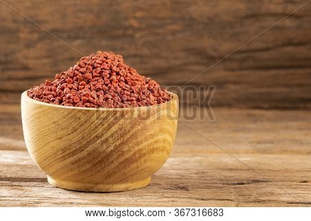 Organic Achiote Seeds - Bixa Orellana. Wood Background