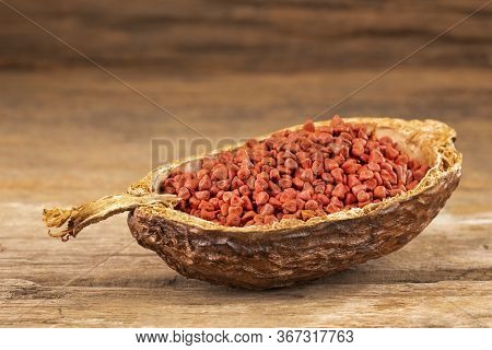 Organic Achiote Seeds - Bixa Orellana. Wood Background
