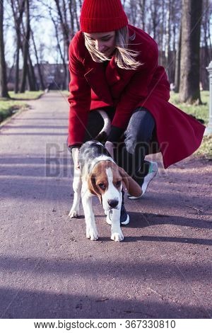 Pretty Young Girl In Redd Coat Playing With Dog Outside In Green Park, Lifestyle People Concept