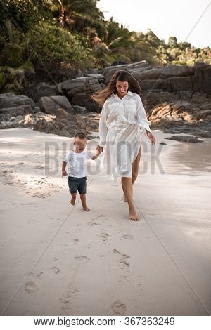 Happy Smile European Family Have Rest And Run On White Sand Beach