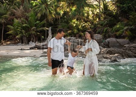 Happy Smile European Family Have Rest And Run On White Sand Beach. Father, Long Black Chestnut Hair