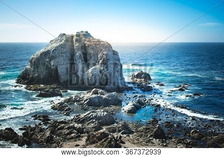 Rocky Island With Birds Near Coastilne Of Pacific Ocean In Chile