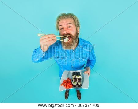 Man Eating Sushi. Sushi. Man With Sushi On Chopstick. Japan. Sushi Delivery. Japanese Food. Pickled 