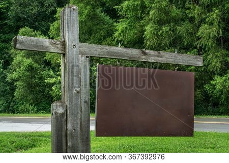 blank park entrance or trailhead sign against green trees