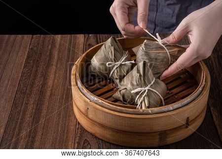Rice Dumpling, Zongzi - Bunch Of Chinese Traditional Cooked Food On Wooden Table Over Black Backgrou