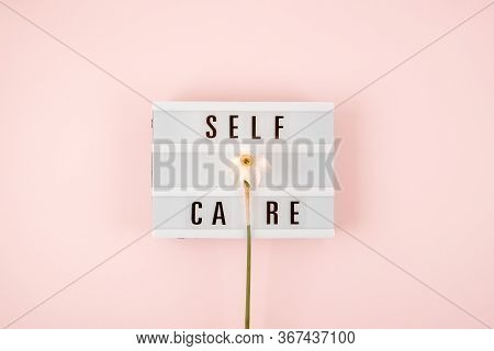 Self-care Word On Lightbox And Flower Narcissus On Pink Background Flat Lay. Take Care Of Yourself.