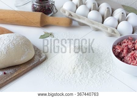 Flour Lies On The Table, Next To Minced Meat, Eggs, Dough. Dumplings, Russian Cuisine. Sculpt Buuzy,