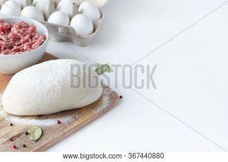 The Dough Lies On The Table, Next To Minced Meat, Eggs, Flour. White Background. Dumplings, Russian 
