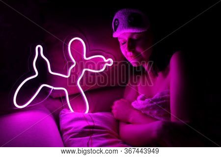 A Beautiful Girl Is Sleeping In A Sleep Blindfold With A Purple Neon Sign Dog. Good Night. Trendy St