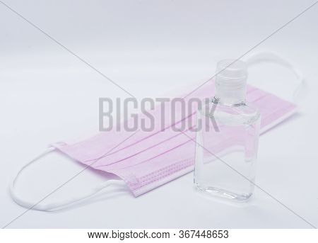 Sanitizer Jel Bottle With Pink Face Masks Isolated On White Background.