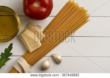 Cooking Ingredients On White Wooden Rustic Background. Pasta, Uncoocked Spaghetti, Egg, Parmesan, Pa