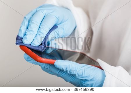 Hands In Protective Gloves And Siut Cleaning Phone From Dust And Infection On White Background