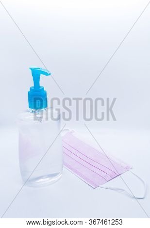 Sanitizer Jel Bottle With Pink Face Masks Isolated On White Background.