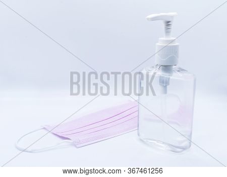 Sanitizer Jel Bottle With Pink Face Masks Isolated On White Background.