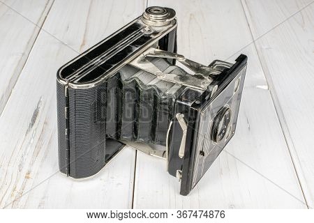 One Whole Opened Vintage Camera On White Wood