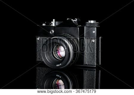 One Whole Black Vintage Camera Isolated On Black Glass