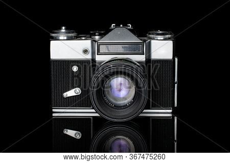 One Whole Old Vintage Camera Silver Black Isolated On Black Glass