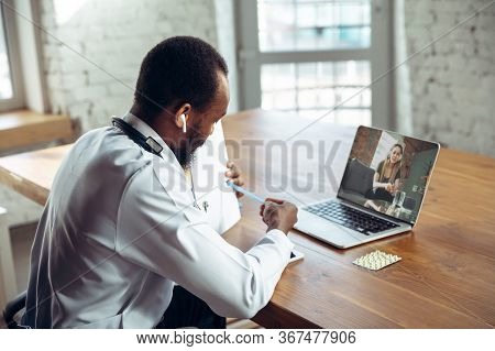 Doctor Advising The Patient Online With Laptop. African-american Doctor During His Work With Patient