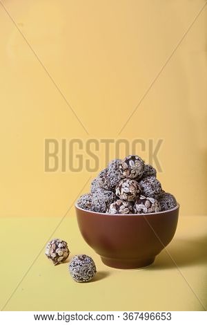 Energy Balls Of Dried Fruits And Nuts Sprinkled With Sesame And Granola Lie On A Blue Porcelain Plat