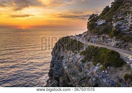 Winding Road Along Rocky Coast Of Cap Corse Peninsula On Corsica Island At Sunset, France