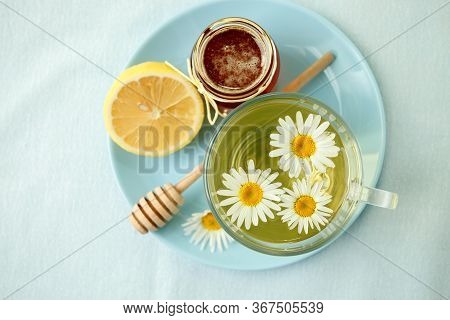 Chamomile Flowers And Chamomile Tea. Chamomile Tea In Glass Teacup With Flowers, Honey And Lemon, To