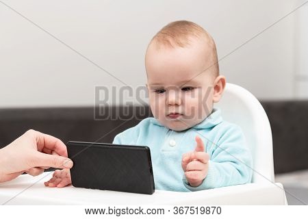 Baby Child Holds Mobile Phone In His Hands